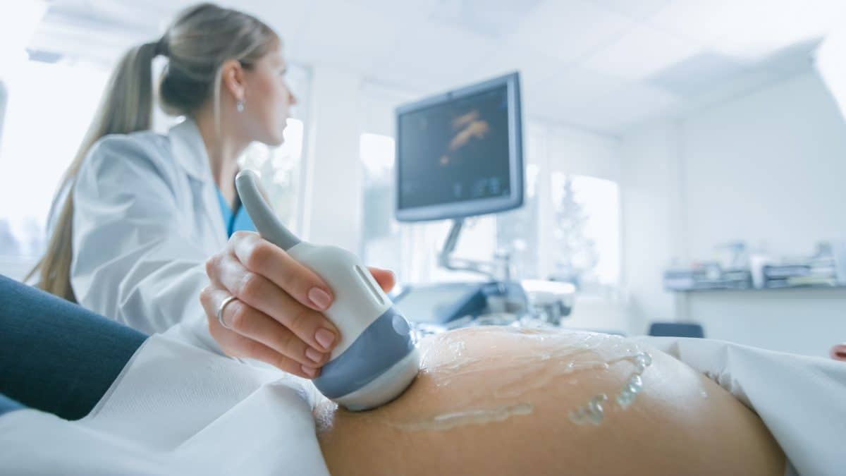 doctor performing ultrasound on pregnant woman