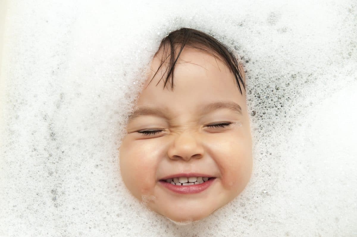 baby smiling in a bubble bath