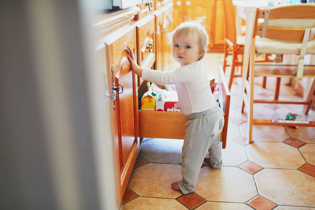 toddler opening kitchen drawer