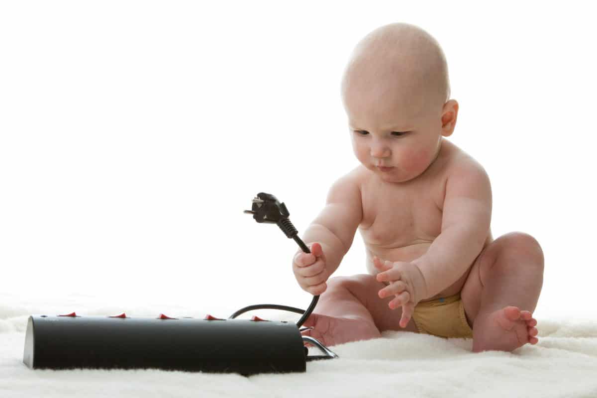 baby playing with power cables.