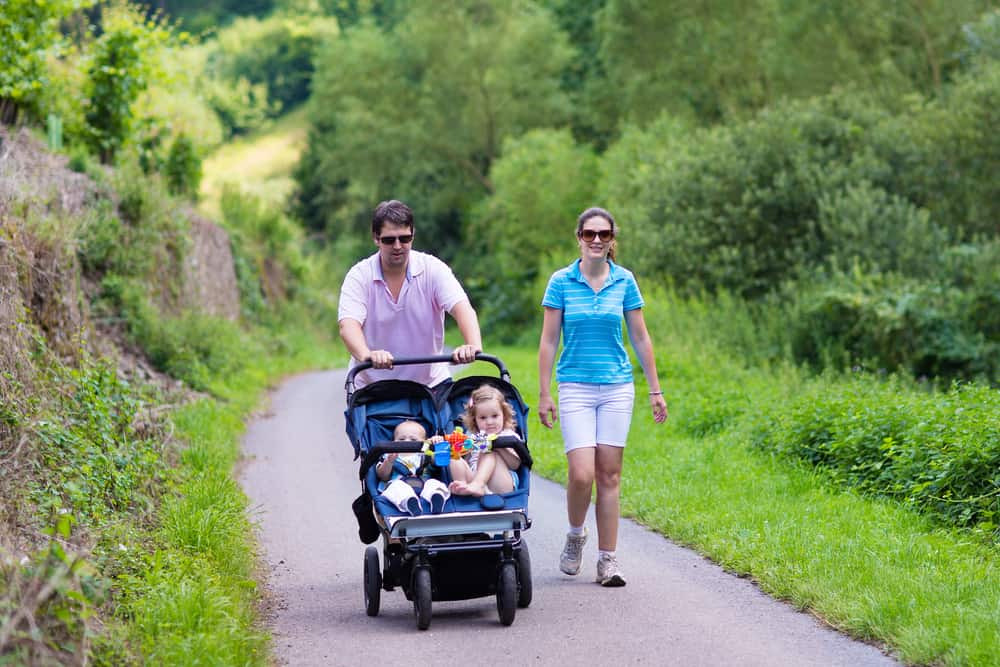 Family in a double stroller walking down a path