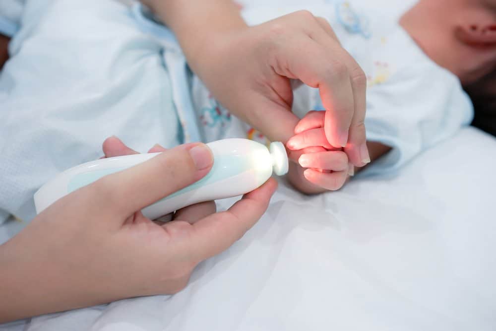 Parent filing baby fingernail while lit up