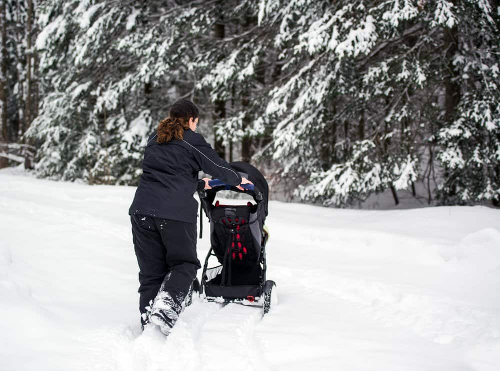 Woman pushing a stroller through the snow