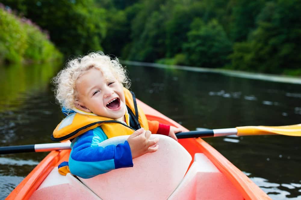 baby in kayak wearing life jacket