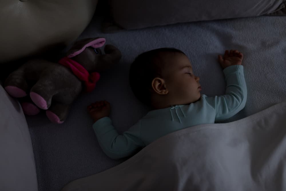 child resting in crib after baby sleep training
