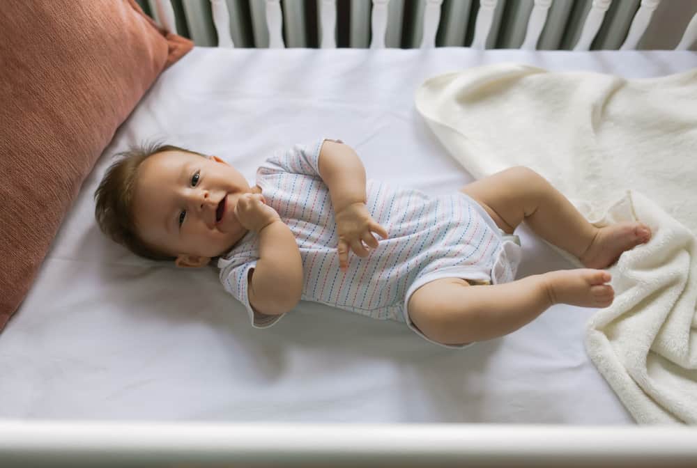 happy baby lying in crib