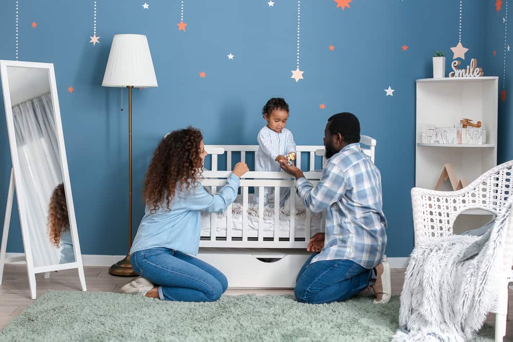 parents watching baby in a crib