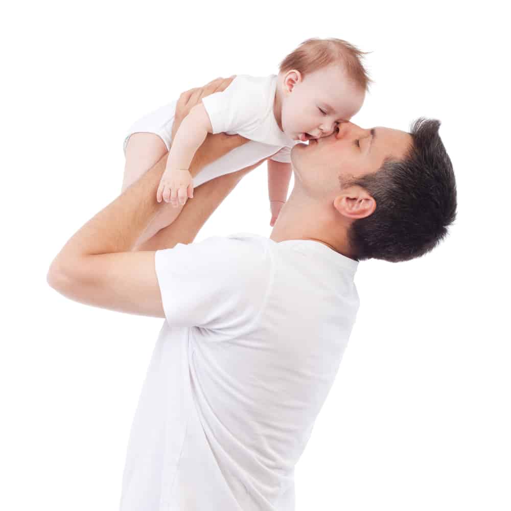 young man kissing his child during sleep training