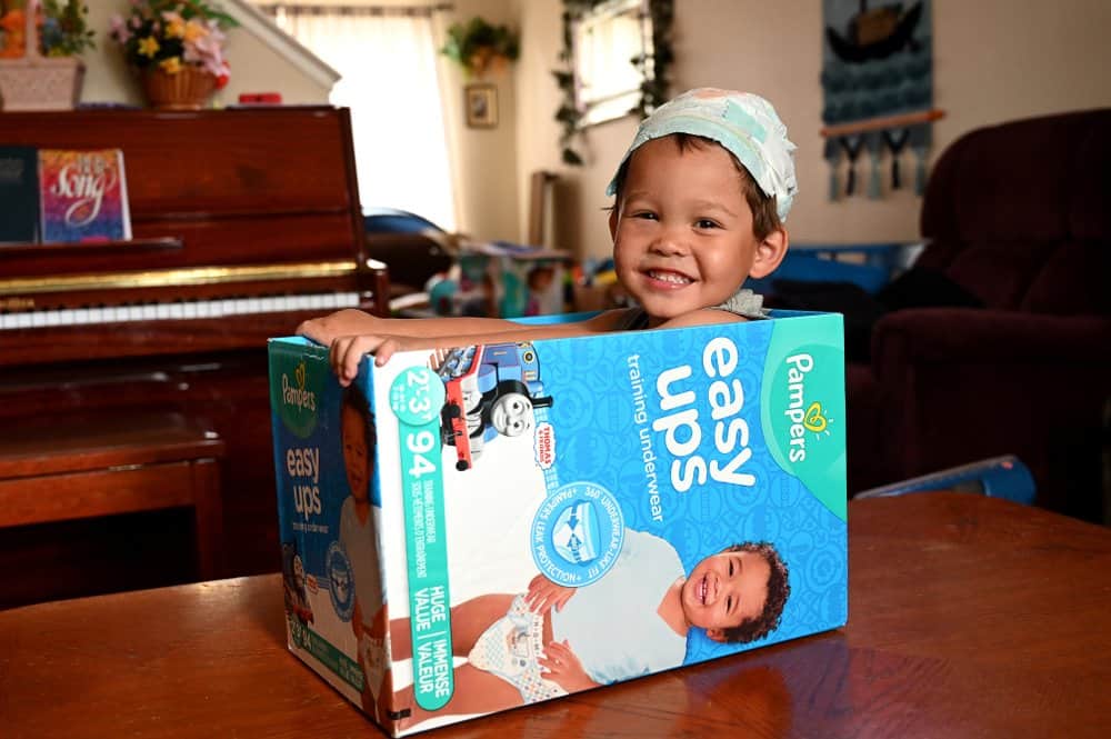child playing in diaper box