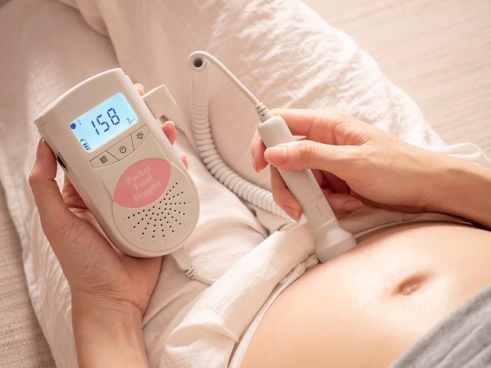 pregnant woman using a fetal Doppler