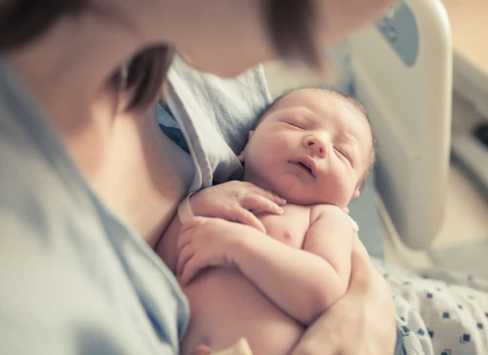 baby sleeping in woman’s arms