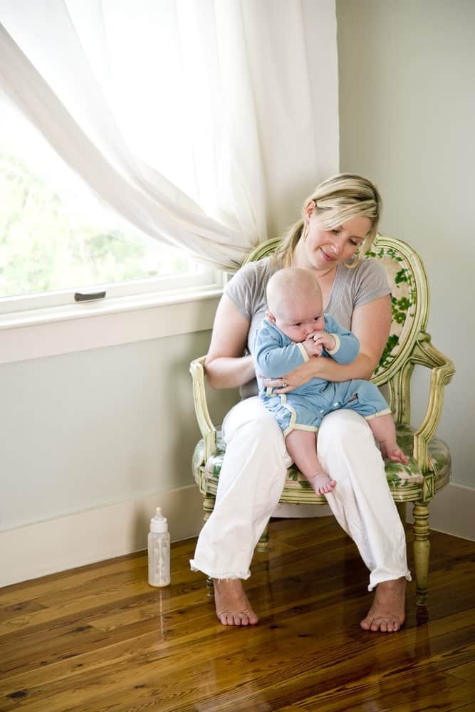 mom burping baby on her lap in a chair