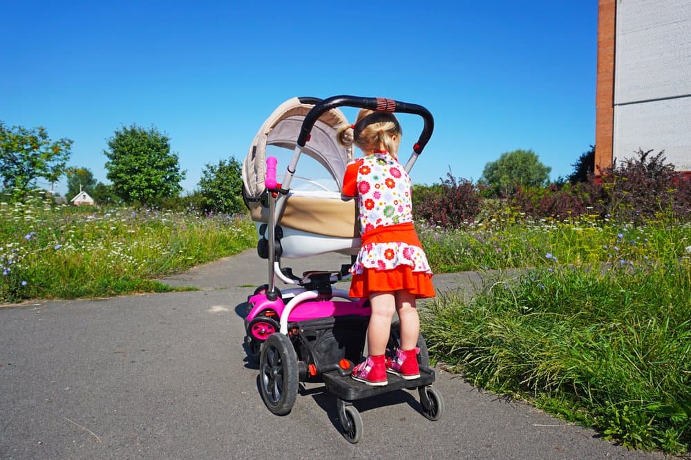 little girl rides on a stroller board