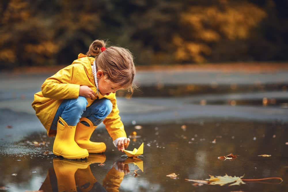 toddler playing in rain boots