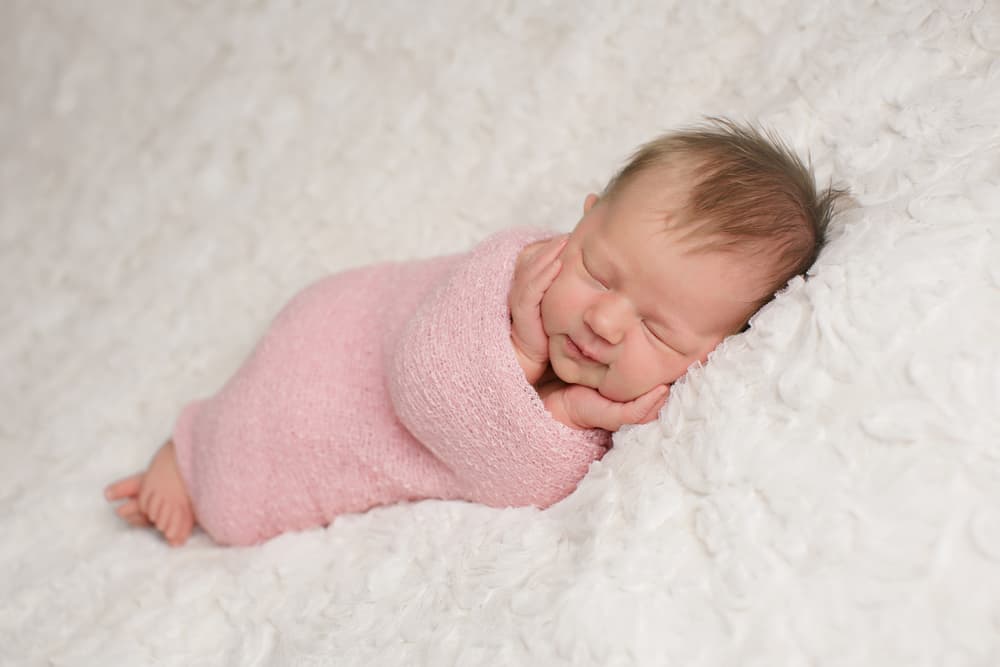 girl sleeping in a pink swaddle