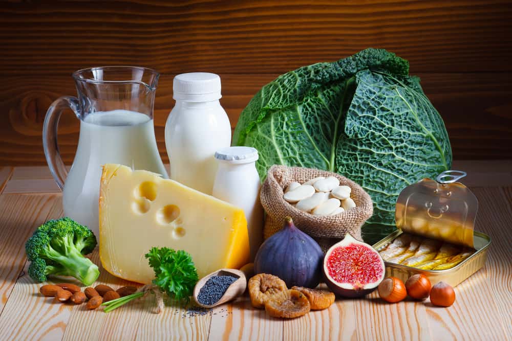a platter of calcium-rich foods like milk, cheese, leafy greens, figs and almonds