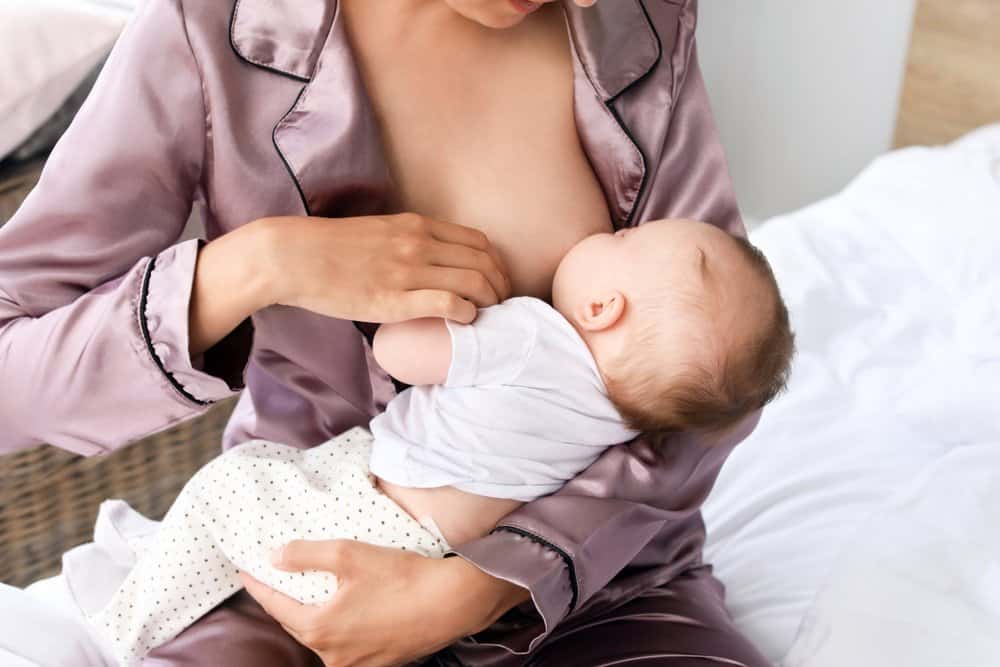 mom breastfeeding baby in pajamas