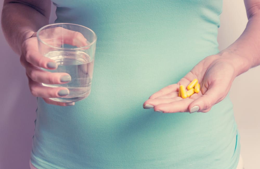 pregnant woman holding supplements