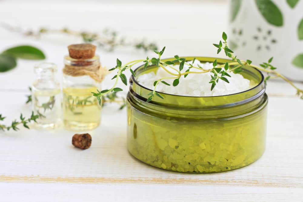 green jar of salts and containers with oils