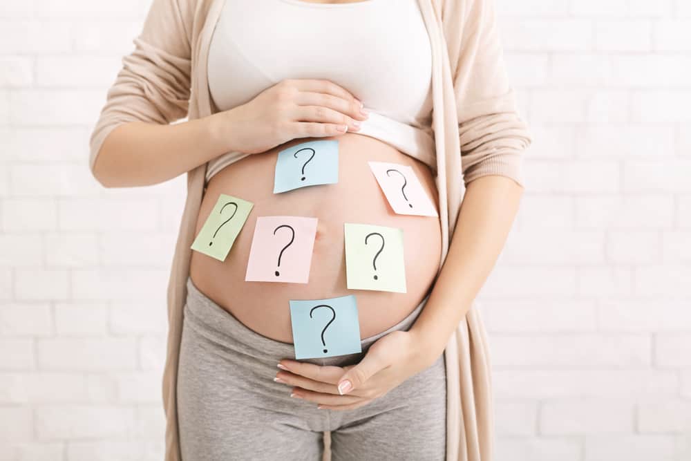 a pregnant woman with question marks on her stomach