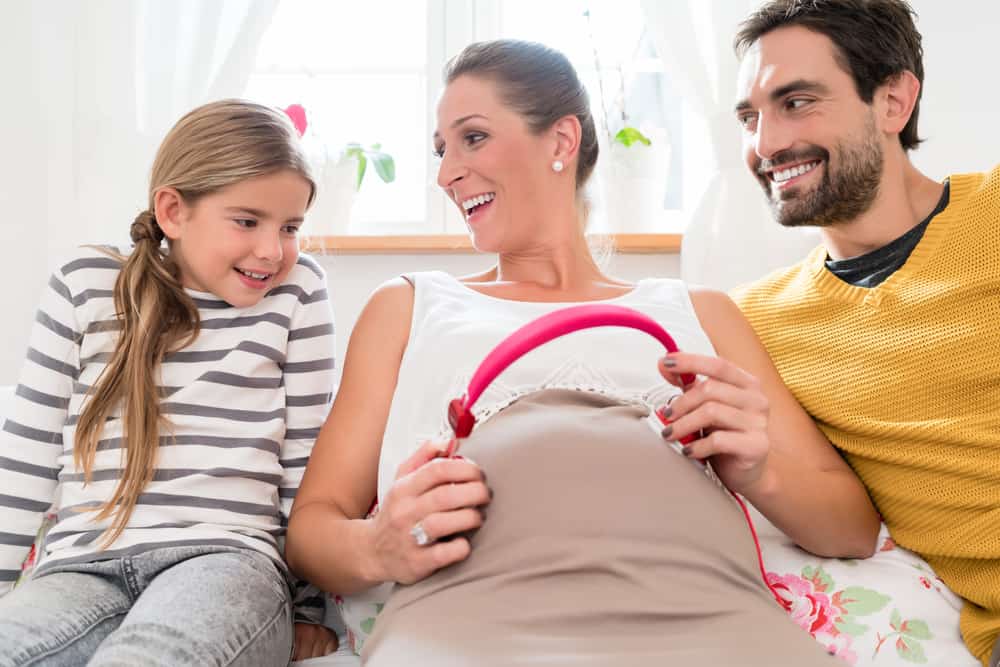 Father, daughter, and pregnant mother with a fetal music system