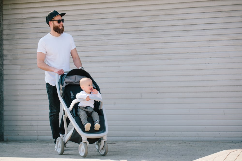 Bearded man pushes baby in a stroller